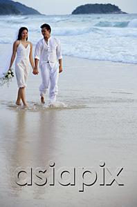 AsiaPix - Bride and groom walking on beach, holding hands