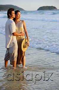 AsiaPix - Couple standing on beach, ankle deep in water