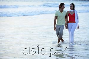 AsiaPix - Couple walking on beach, ankle deep in water, holding hands