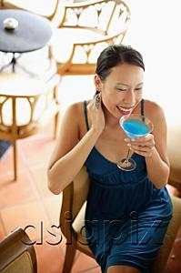 AsiaPix - Woman sitting on chair, drinking cocktail, high angle view