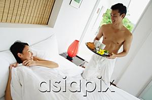 AsiaPix - Woman lying in bed, man holding breakfast tray