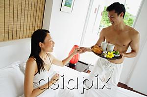 AsiaPix - Woman lying in bed, man holding breakfast tray, holding womans hand