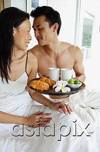 AsiaPix - Couple having breakfast in bed, looking at each other