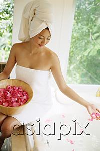 AsiaPix - Woman in towel, sitting at edge of bath tub, throwing flower petals into water
