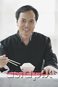 AsiaPix - Man with bowl of rice and chopsticks, smiling at camera