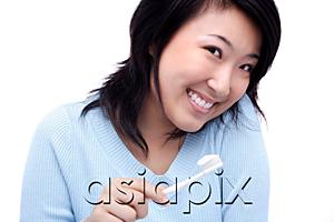 AsiaPix - Young woman with toothbrush, smiling at camera