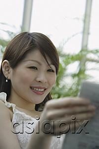AsiaPix - Young woman reading a book, selective focus