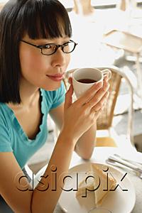 AsiaPix - Young woman having coffee, looking away