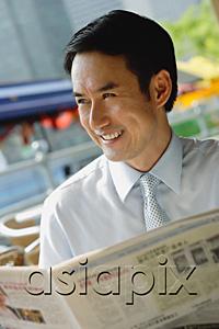 AsiaPix - Businessman in cafe with newspaper, smiling