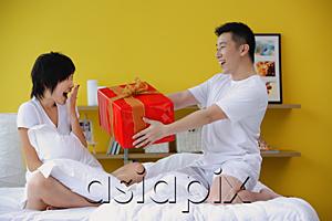AsiaPix - Man giving woman present in bedroom