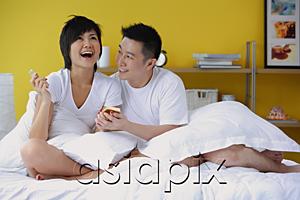 AsiaPix - Couple in bedroom, woman opening present