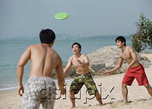 AsiaPix - Three young men on beach playing with Frisbee