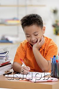 AsiaPix - Boy doing homework, hand on chin