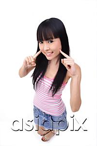 AsiaPix - Young woman with fingers on cheek, smiling at camera