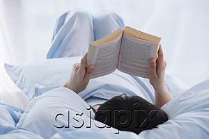 AsiaPix - Young woman reading a book in bed