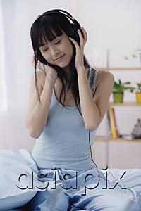 AsiaPix - Young woman using headphones, eyes closed