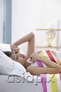 AsiaPix - Young woman lying on bed, rubbing her eyes