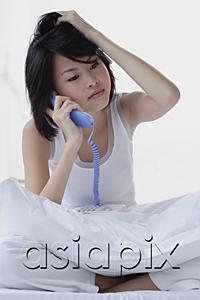 AsiaPix - Young woman using telephone, hand on head
