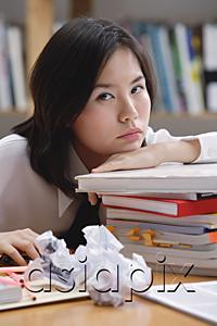 AsiaPix - Young woman in library, leaning on books, sad expression
