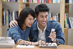AsiaPix - Couple in library, looking at mobile phone