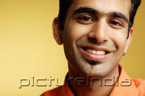 PictureIndia - Man looking at camera, smiling, head shot