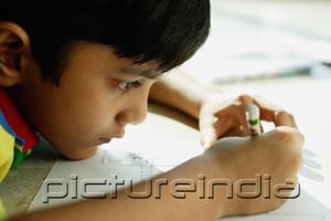 PictureIndia - Boy with chin on floor, drawing with crayons