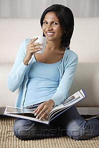 PictureIndia - woman holding a mug, book on her lap