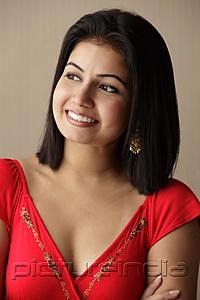 PictureIndia - head shot of woman smiling and looking away, wearing a red dress