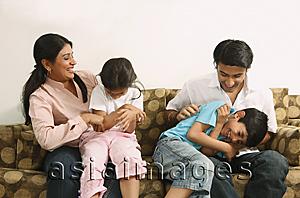 Asia Images Group - Family tickling on couch