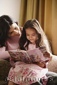 Asia Images Group - mother and daughter look at story book