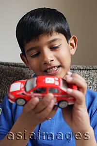 Asia Images Group - boy holding red car (vertical)