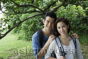 Asia Images Group - Couple with back packs standing under a tree