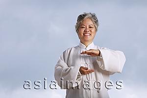 Asia Images Group - Older woman doing martial arts.