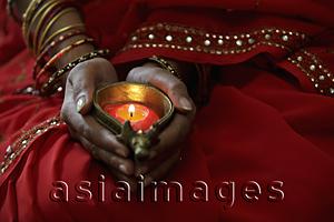 Asia Images Group - Close up of woman wearing red sari and holding lit candle