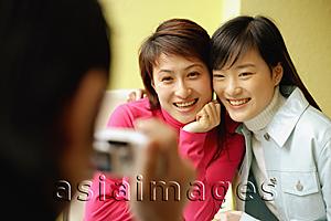 Asia Images Group - Young man holding camera, two women posing for picture