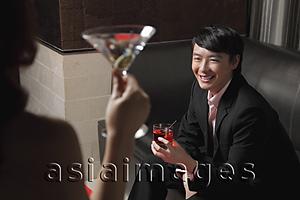 Asia Images Group - Young woman looking at young man holding a drink and smiling