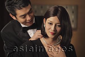 Asia Images Group - Young man putting a diamond necklace onto a woman