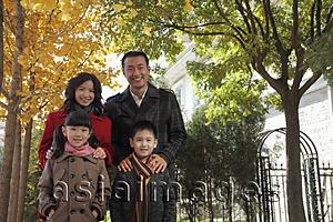 Asia Images Group - Family of four standing together in front of their house
