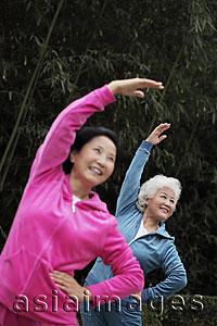 Asia Images Group - Two older woman stretching together outdoors