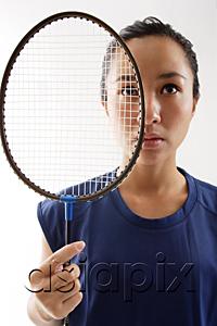 AsiaPix - Woman holding badminton racket next to her face