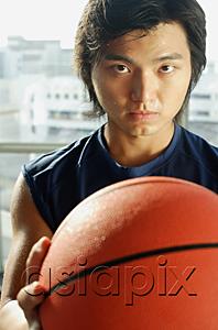 AsiaPix - Man holding basketball, looking at camera