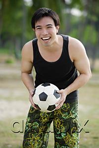 AsiaPix - Man holding soccer ball, smiling at camera