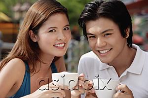 AsiaPix - Couple in cafe having coffee, smiling at camera