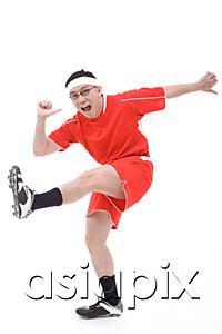 AsiaPix - Man in soccer uniform, kicking leg in air