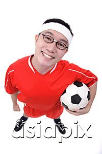 AsiaPix - Man holding soccer ball under arm, looking at camera
